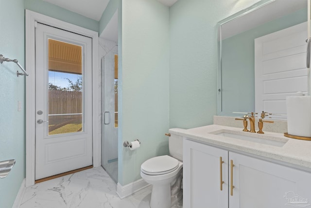 bathroom with marble finish floor, toilet, vanity, a shower stall, and baseboards