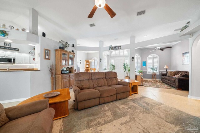 tiled living room with lofted ceiling and ceiling fan