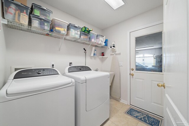 kitchen with white cabinetry, sink, a kitchen island, appliances with stainless steel finishes, and light tile patterned floors