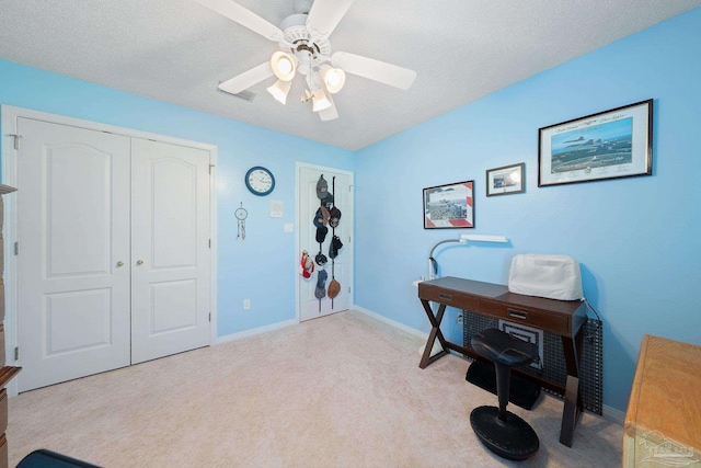 office area with a textured ceiling, ceiling fan, and light colored carpet