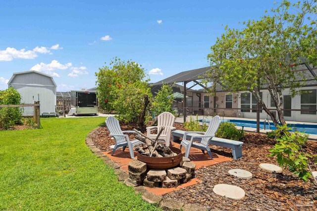 view of yard with a lanai and an outdoor fire pit