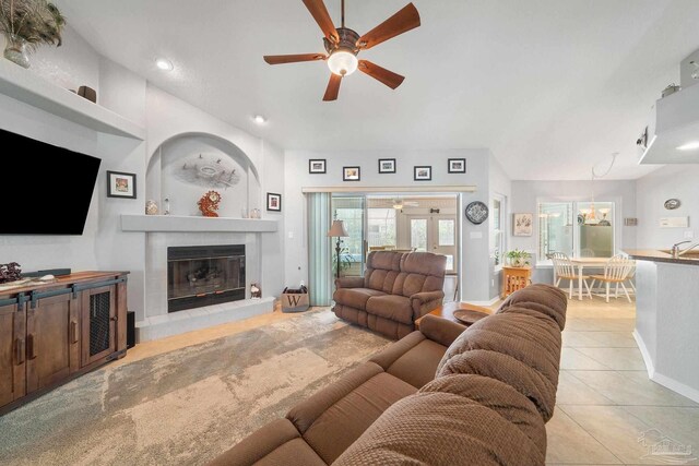 tiled living room featuring sink, a fireplace, and ceiling fan