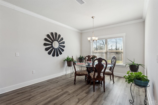 dining room with a notable chandelier, visible vents, baseboards, ornamental molding, and dark wood-style floors