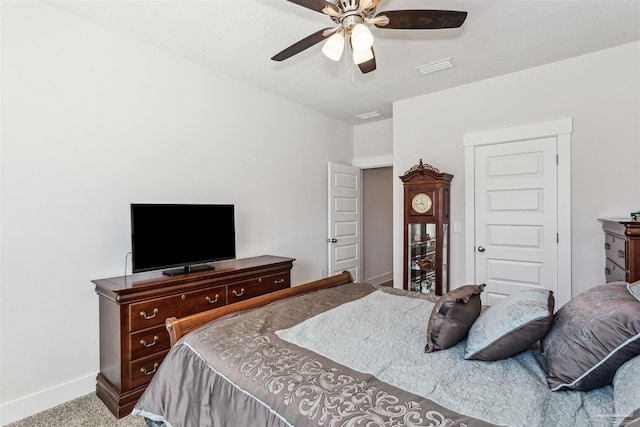 carpeted bedroom featuring ceiling fan, visible vents, and baseboards