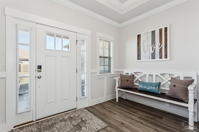 entrance foyer featuring crown molding, a decorative wall, dark wood-type flooring, and wainscoting