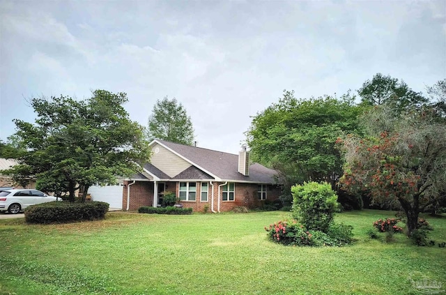 view of front of home with brick siding, a front yard, a chimney, and a garage