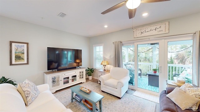 living room featuring ceiling fan and light hardwood / wood-style floors