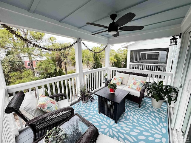 deck with ceiling fan, a sunroom, and an outdoor living space