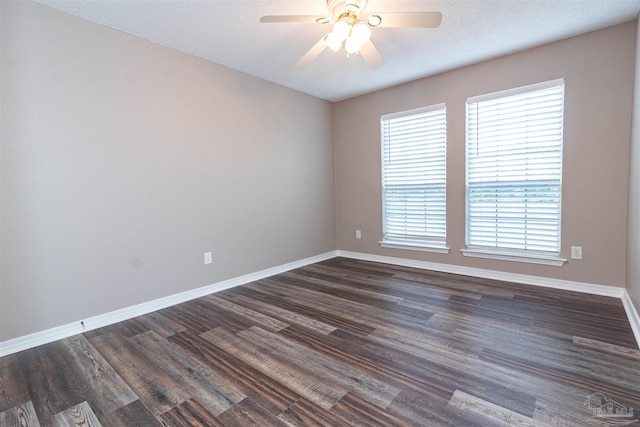 unfurnished room featuring healthy amount of natural light, baseboards, a ceiling fan, and dark wood finished floors