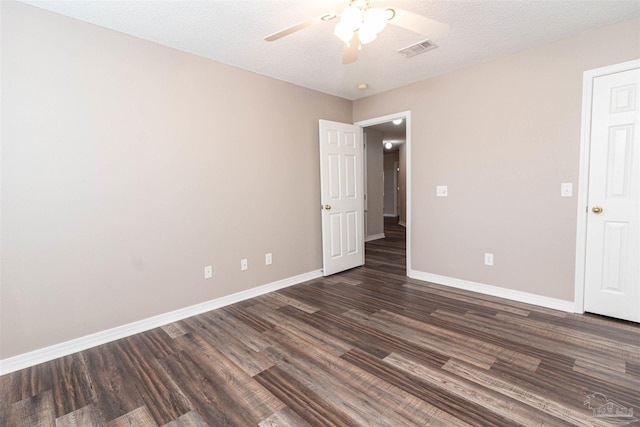 empty room with ceiling fan, dark wood finished floors, and baseboards