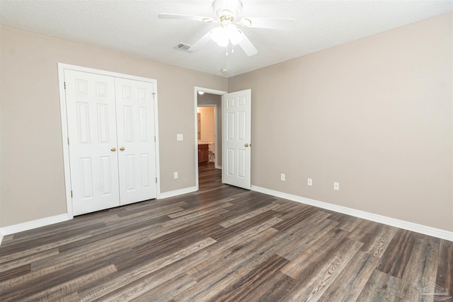 unfurnished bedroom with dark wood finished floors, a closet, baseboards, and ceiling fan