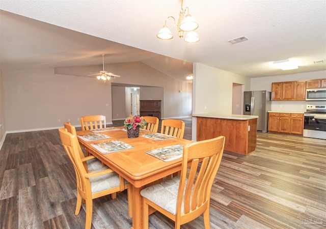 dining space featuring light wood-type flooring, vaulted ceiling, a chandelier, ceiling fan, and a textured ceiling
