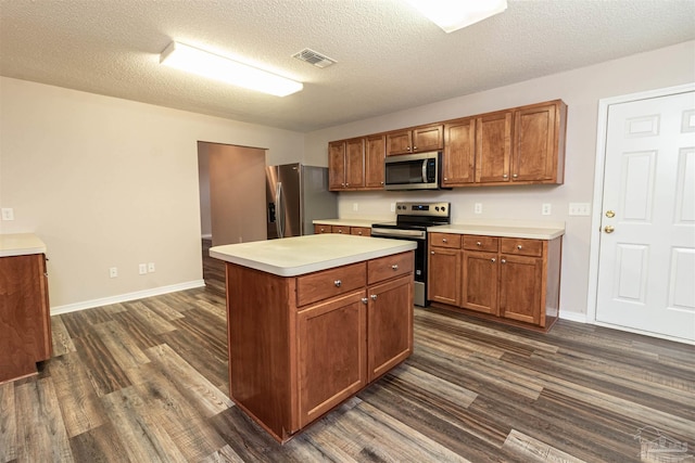 kitchen featuring appliances with stainless steel finishes, dark wood finished floors, light countertops, brown cabinets, and baseboards