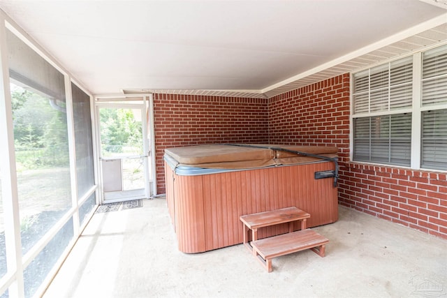 unfurnished sunroom with a hot tub