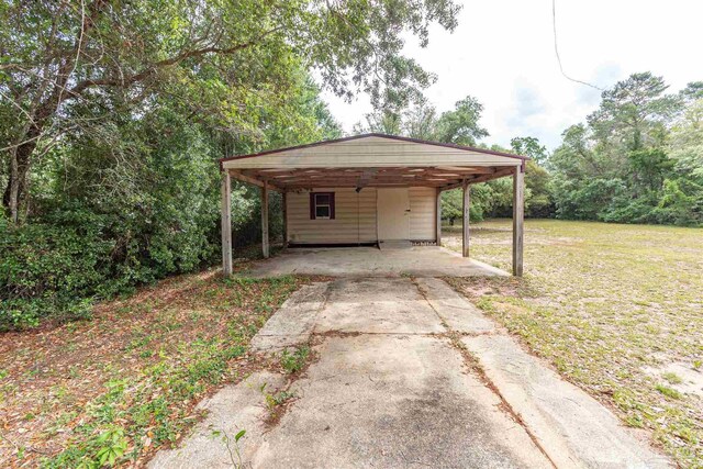 view of outbuilding with a carport and concrete driveway