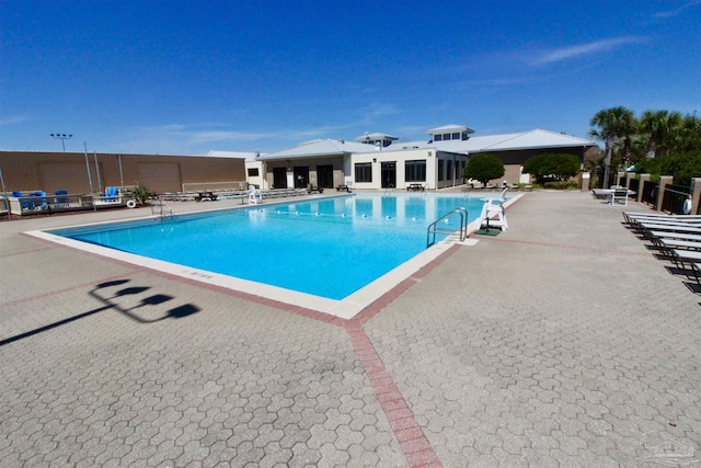 community pool featuring a patio area and fence