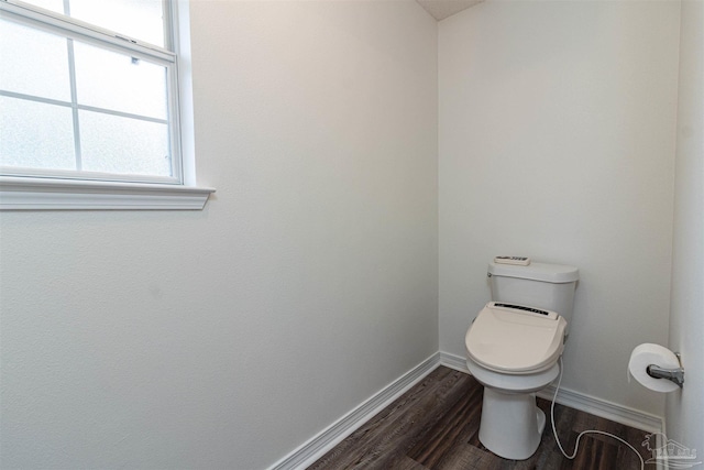 bathroom with plenty of natural light, baseboards, wood finished floors, and toilet