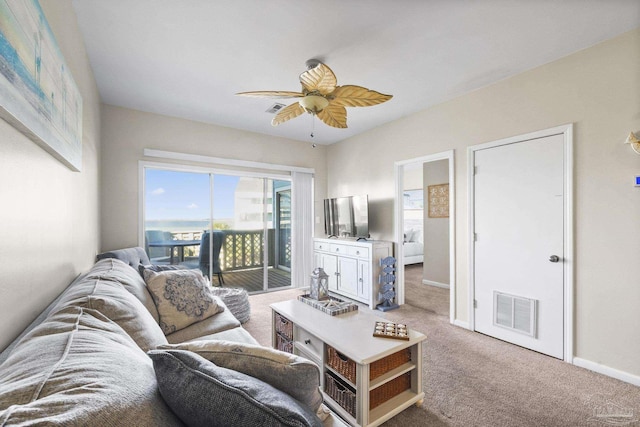 carpeted living room with ceiling fan