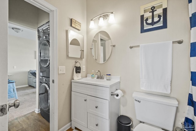 bathroom with vanity, toilet, and stacked washer / dryer