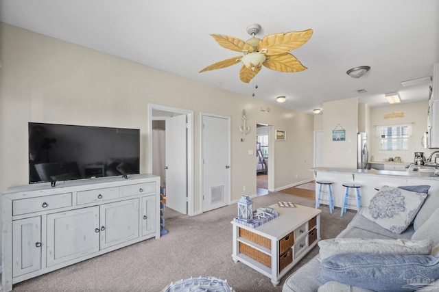 carpeted living room featuring ceiling fan