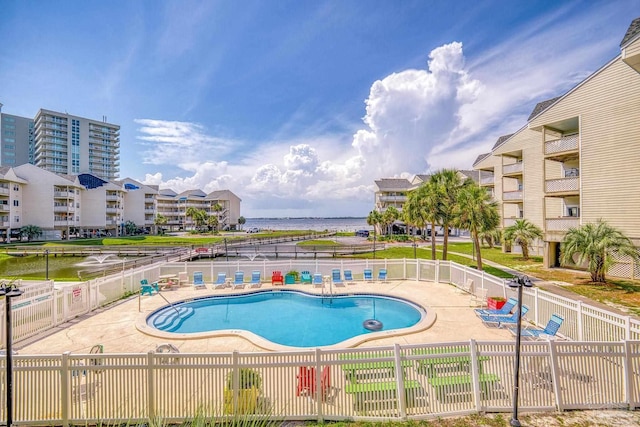 view of pool with a patio and a water view