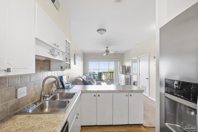 kitchen featuring white cabinetry, sink, ceiling fan, kitchen peninsula, and decorative backsplash