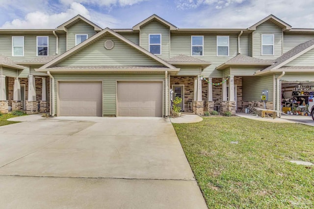 view of front of property with a shingled roof, a front yard, driveway, and an attached garage