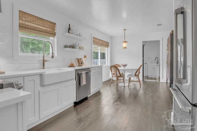 6050 Cheyenne Dr, Milton, FL 32570 - kitchen with stainless steel appliances, wood finished floors, light countertops, white cabinetry, and pendant lighting