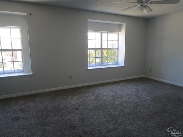 spare room featuring ceiling fan, a textured ceiling, and dark colored carpet