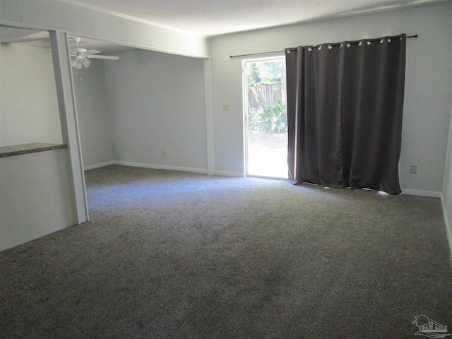 spare room with ceiling fan, a textured ceiling, and carpet