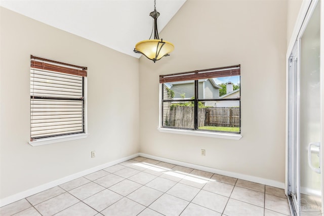 spare room with baseboards, light tile patterned floors, and high vaulted ceiling