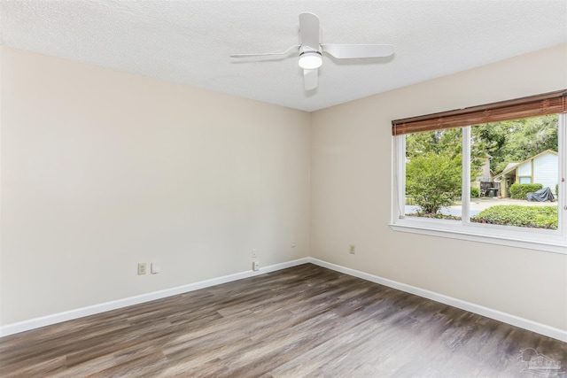 unfurnished room featuring baseboards, a ceiling fan, a textured ceiling, and dark wood-type flooring