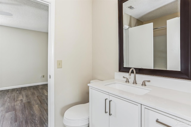 bathroom with toilet, a textured ceiling, visible vents, and vanity
