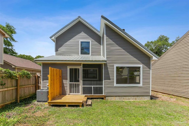 back of house with fence, a lawn, a sunroom, and cooling unit