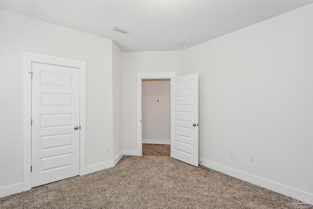 unfurnished bedroom with a closet and carpet floors