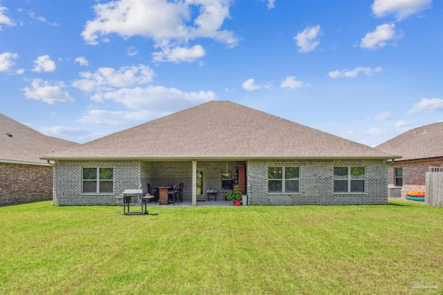 rear view of house featuring a lawn and a patio area