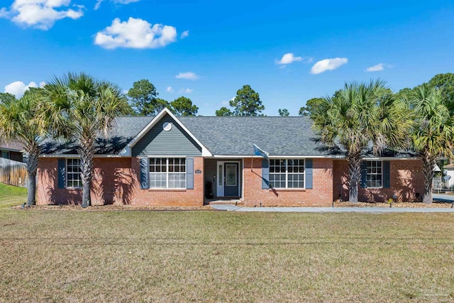 ranch-style house with brick siding, a front lawn, and roof with shingles