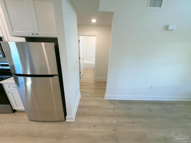 kitchen with white cabinetry, light wood-style floors, visible vents, baseboards, and appliances with stainless steel finishes