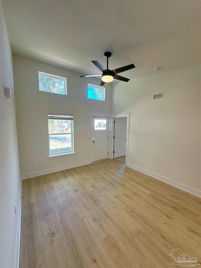 unfurnished living room featuring ceiling fan, light wood-type flooring, visible vents, and baseboards