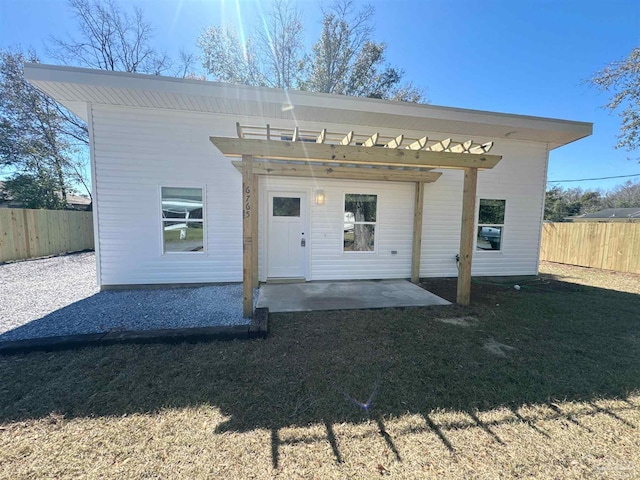 view of front of home featuring a front yard, a fenced backyard, a patio, and a pergola