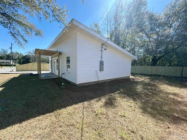 view of side of property featuring a lawn and fence