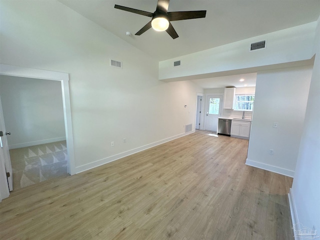 unfurnished living room with light wood-type flooring, baseboards, visible vents, and vaulted ceiling