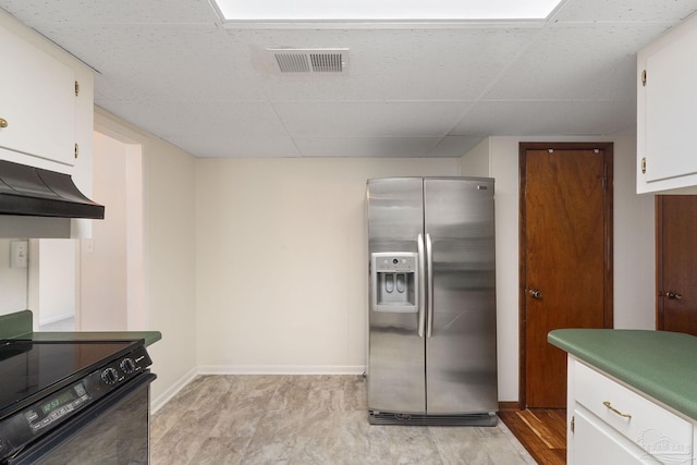 kitchen featuring stainless steel refrigerator with ice dispenser, light wood-type flooring, a paneled ceiling, black range oven, and white cabinetry