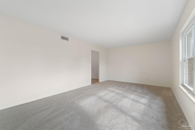 carpeted empty room featuring plenty of natural light