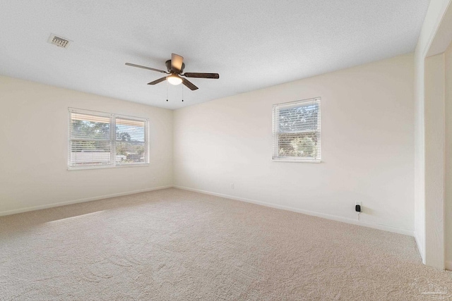 unfurnished room with carpet, ceiling fan, and a wealth of natural light