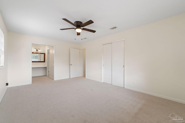 unfurnished bedroom featuring light carpet, a closet, and ceiling fan