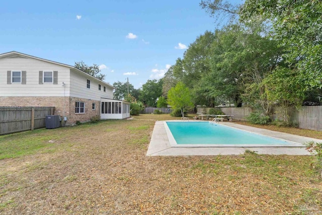 view of swimming pool featuring a sunroom, central AC, and a lawn