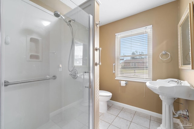 bathroom with toilet, a shower with door, tile patterned floors, and plenty of natural light