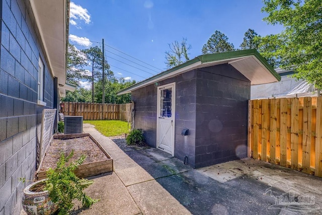 3171 Montecito Blvd, Milton, FL 32583 - view of outbuilding with a fenced backyard, an outdoor structure, a garden, and central AC unit