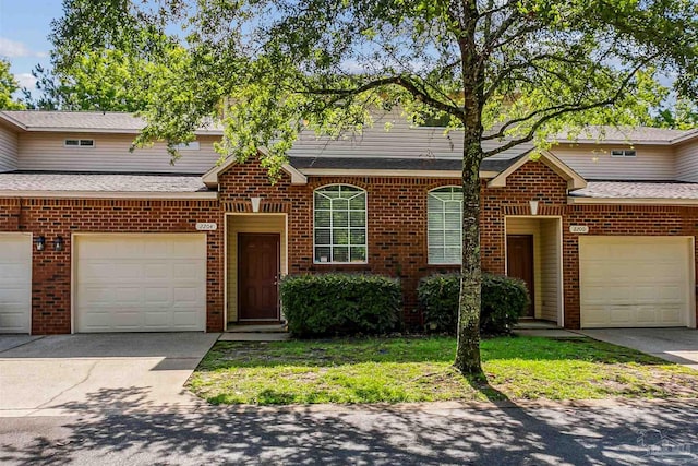 view of front property featuring a garage and a front lawn